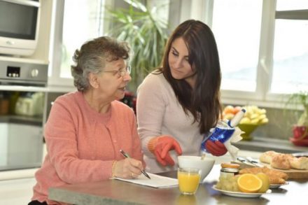 Homecare helping elderly woman doing crossword